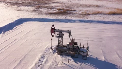 Pump jack in vast oil fields in winter. Pipelines transporting oil from oil Stock Footage 171919022