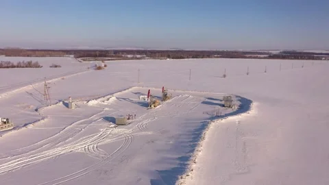 Pump jack in vast oil fields in winter. Pipelines transporting oil from oil Stock Footage 172054135