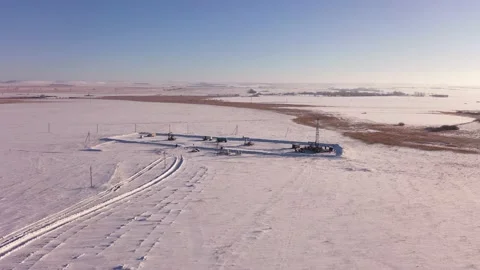 Pump jack in vast oil fields in winter. Pipelines transporting oil from oil Stock Footage 174870982