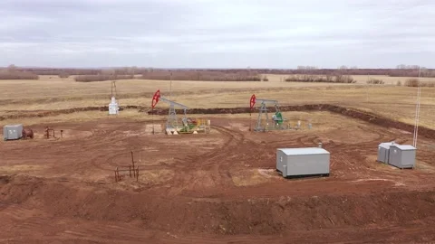 Pump jack in vast oil fields in Russia. Pipelines transporting oil from oil Stock Footage 178557047