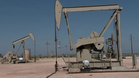 Pump jacks pumping out oil in steady rythm, 4K. Stock Footage 79979940