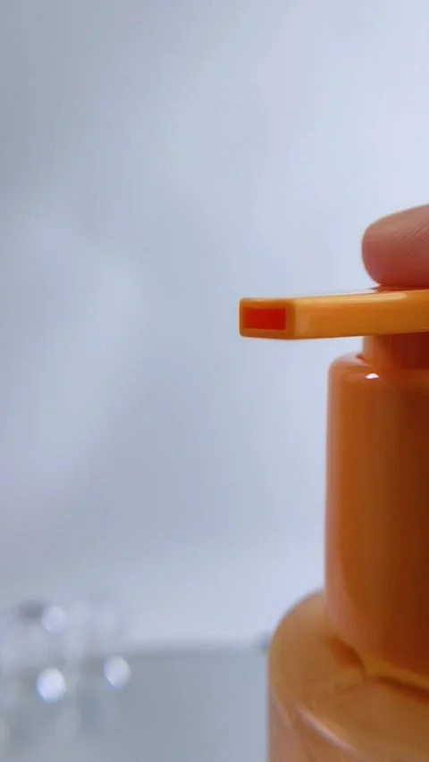 Pump releasing clear liquid from orange product packaging. Close up of vita.. Stock Footage 336238761