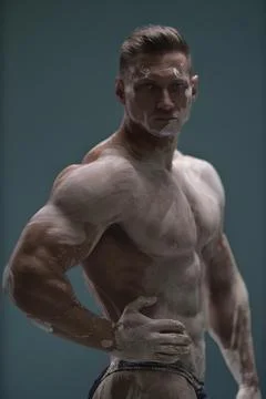 Pumped up athletic handsome man posing in white clay Stock Photos