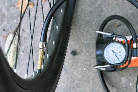 Pumping up a bicycle tire using an electric air car compressor Fotos de archivo