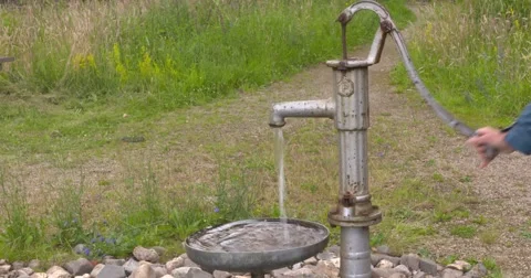 Pumping up groundwater by hand using a traditional pump. Stock Footage 65451276