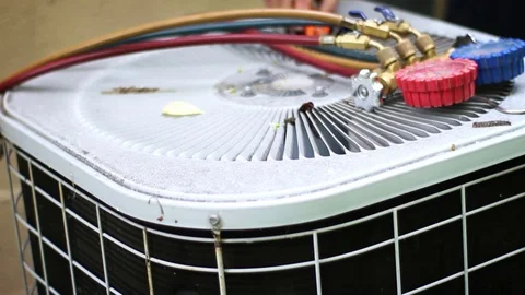 Pumping refridgerant out of old air conditioner unit with technician gear and ca Stock Footage 75871548
