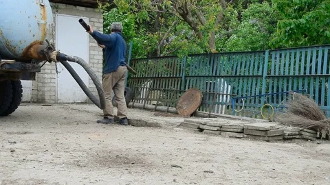 Pumping of sewage. Worker extort sewage with help of motor pump Stock Footage 70568302