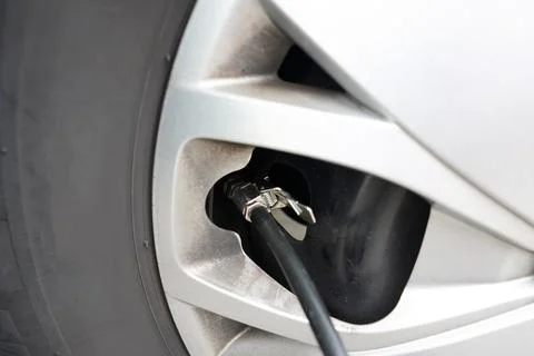 Pumping the tire at the station with the compressor. Checking pressure. Stock Photos