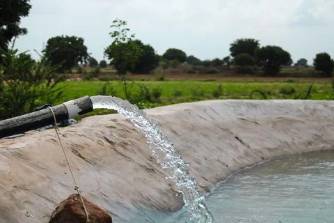 Pumping water out of plastic pipe into the ground,Water from a well filled a  Stock Photos