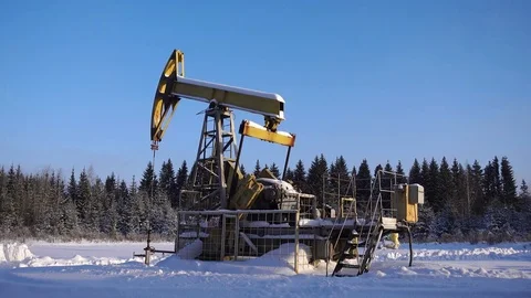 Pumpjack, oil pumping unit against a beautiful forest landscape Stock Footage 84701743
