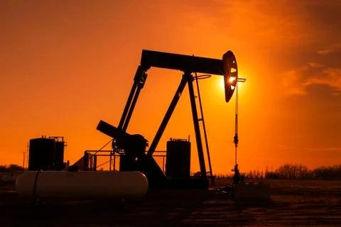 Pumpjack at sunset; Alberta, Canada Stock Photos