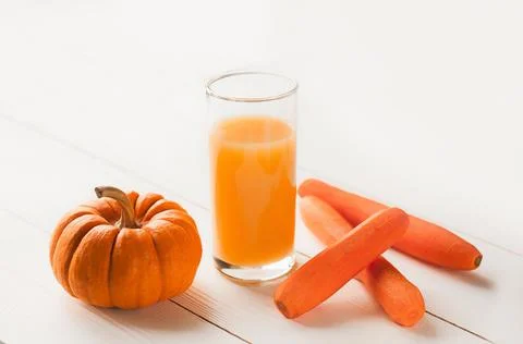 Pumpkin and Carrot smoothie in white wooden background. close-up view of natu Stock Photos