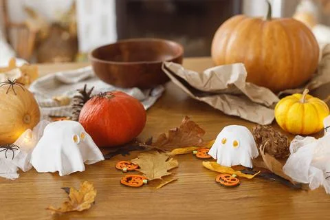 Pumpkin and knife, cobweb, ghosts and spiders on table in living room. Hall.. Stock Photos