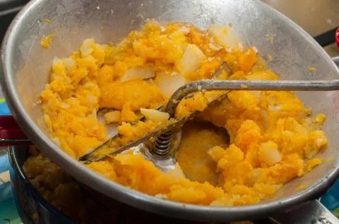 Pumpkin and potatoes mashed in vegetable mill masher Stock Photos