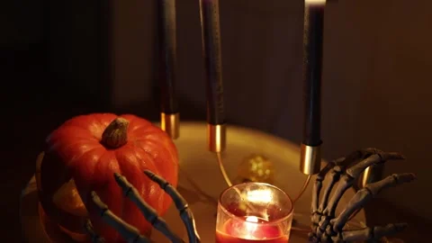 Pumpkin and skeleton hands create spooky Halloween decor by candlelight Stock-Footage 346147479