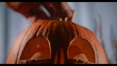 Pumpkin Carving Process Showing a Hand Placing the Lid on Carved Jack O Lantern Vídeos de archivo 331110421