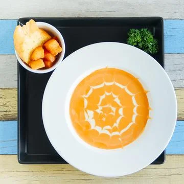Pumpkin cream soup with white pattern and toasted white bread Stock Photos
