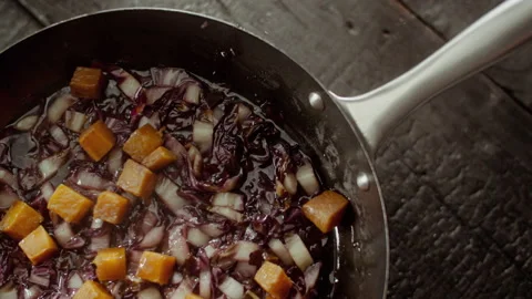 Pumpkin cubes falling into a pan full of stir-fried radicchio Stock Footage 135007703