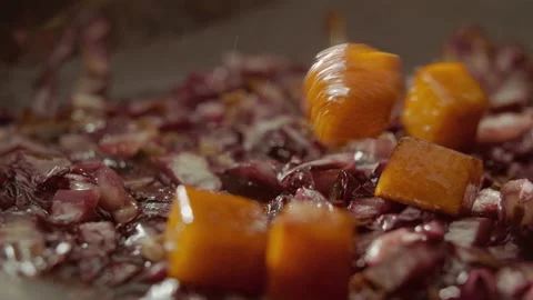 Pumpkin cubes falling into a pan full of stir-fried radicchio (close up) Stock Footage 135046548