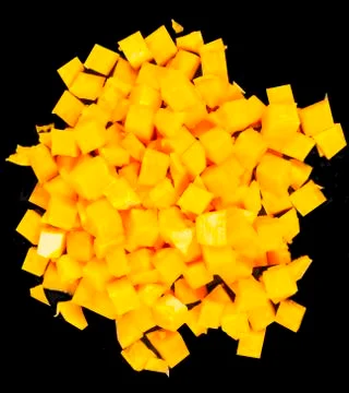 Pumpkin cutted in small square blocks on black background Stock Photos
