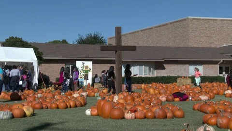 Pumpkin display in front of Church as camera zooms in to a cross, 4K. Stock Footage 80896393