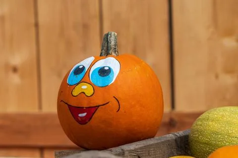 Pumpkin face on a crate full of pumpkins Stock Photos