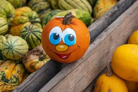 Pumpkin face on a crate full of pumpkins Foto stock
