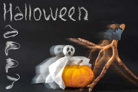 Pumpkin, ghost and bats on black background with inscription Happy Halloween Stock Photos