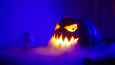 Pumpkin with glowing eyes and an evil smile lets out smoke for Halloween 動画素材 217368974