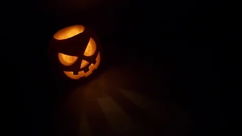 Pumpkin head on black background for Halloween. Evil face. Flickering candle. A Stock Footage 115134454