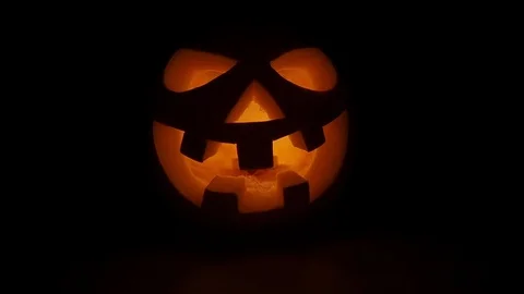 Pumpkin head on black background for Halloween. Evil face. Flickering candle. A Stock Footage 115135016