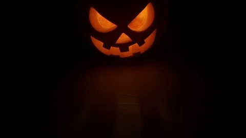 Pumpkin head on black background for Halloween. Evil face. Flickering candle. A Stock Footage 115135363