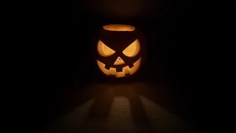 Pumpkin head on black background for Halloween. Evil face. Flickering candle. A Stock Footage 115135669
