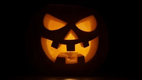 Pumpkin head on black background for Halloween. Evil face. Flickering candle. A Stock Footage 115136046