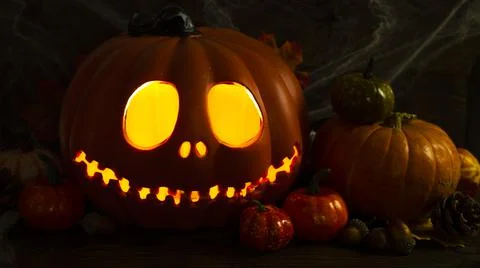 Pumpkin head Jack-o'-lantern close-up with glowing eyes and orange autumn Stock Photos