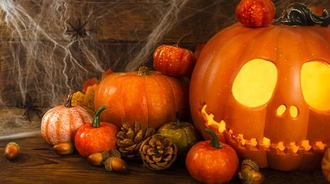 Pumpkin head Jack-o'-lantern close-up with glowing eyes and orange autumn Stock Photos