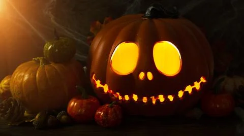 Pumpkin head Jack-o'-lantern close-up with glowing eyes and orange autumn Stock Photos