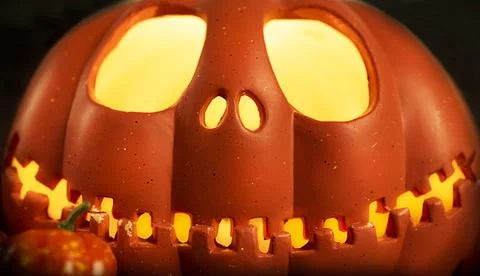Pumpkin head Jack-o'-lantern close-up with glowing eyes and orange autumn Stock Photos