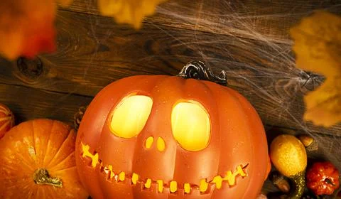 Pumpkin head Jack-o'-lantern and different small pumpkins, cones, acorns and Stock Photos