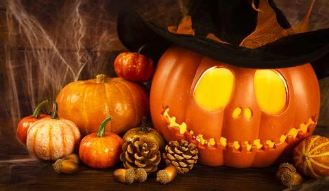 Pumpkin head Jack-o'-lantern and different small pumpkins, cones, acorns and Foto stock