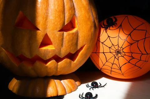 Pumpkin head Jack-o-lantern and different small spiders on a black background Stock Photos