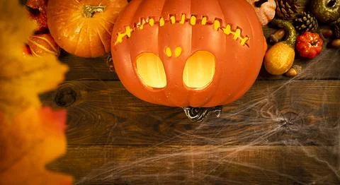 Pumpkin head Jack-o'-lantern and different small pumpkins, cones, acorns and Stock Photos