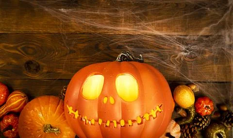 Pumpkin head Jack-o'-lantern and different small pumpkins, cones, acorns and Stock Photos