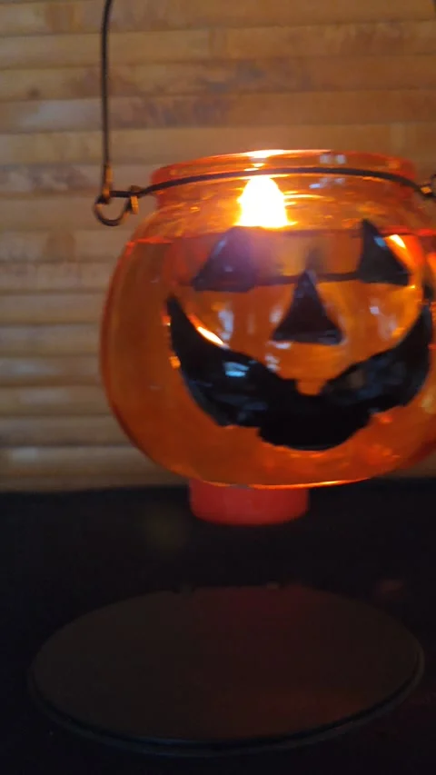 A pumpkin lantern with a candle in the dark, macro shot, held in hand Stock Footage 319789357