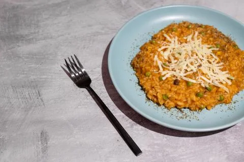 Pumpkin peas risotto with parmesan topping on concrete table Stock Photos