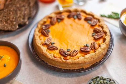 Pumpkin pie decorated with pecans on a served table for an autumn party food Stock Photos