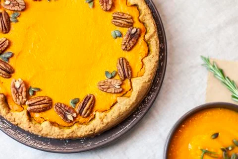 Pumpkin pie decorated with pecans on a served table for an autumn party food Stock Photos