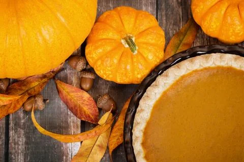 Pumpkin pie with pumpkins and autumn decorations on rustic table Foto stock