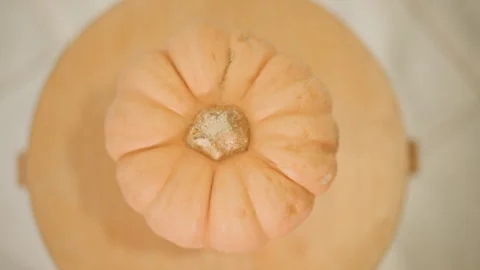 Pumpkin placed on round surface with tiled floor background. Presentation of Stock Footage 346390084