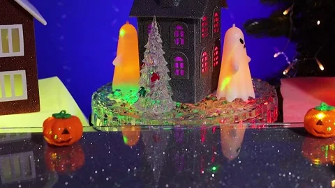 An pumpkin pops up against rotating house, surrounded glowing ghost figures Stock-Footage 346601650